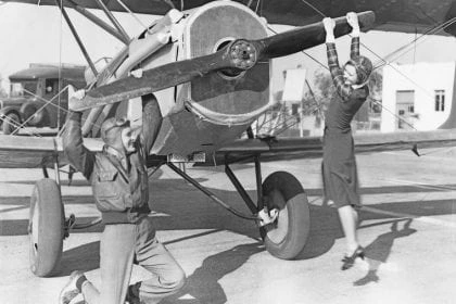 Man-and-woman-pulling-plane-propeller